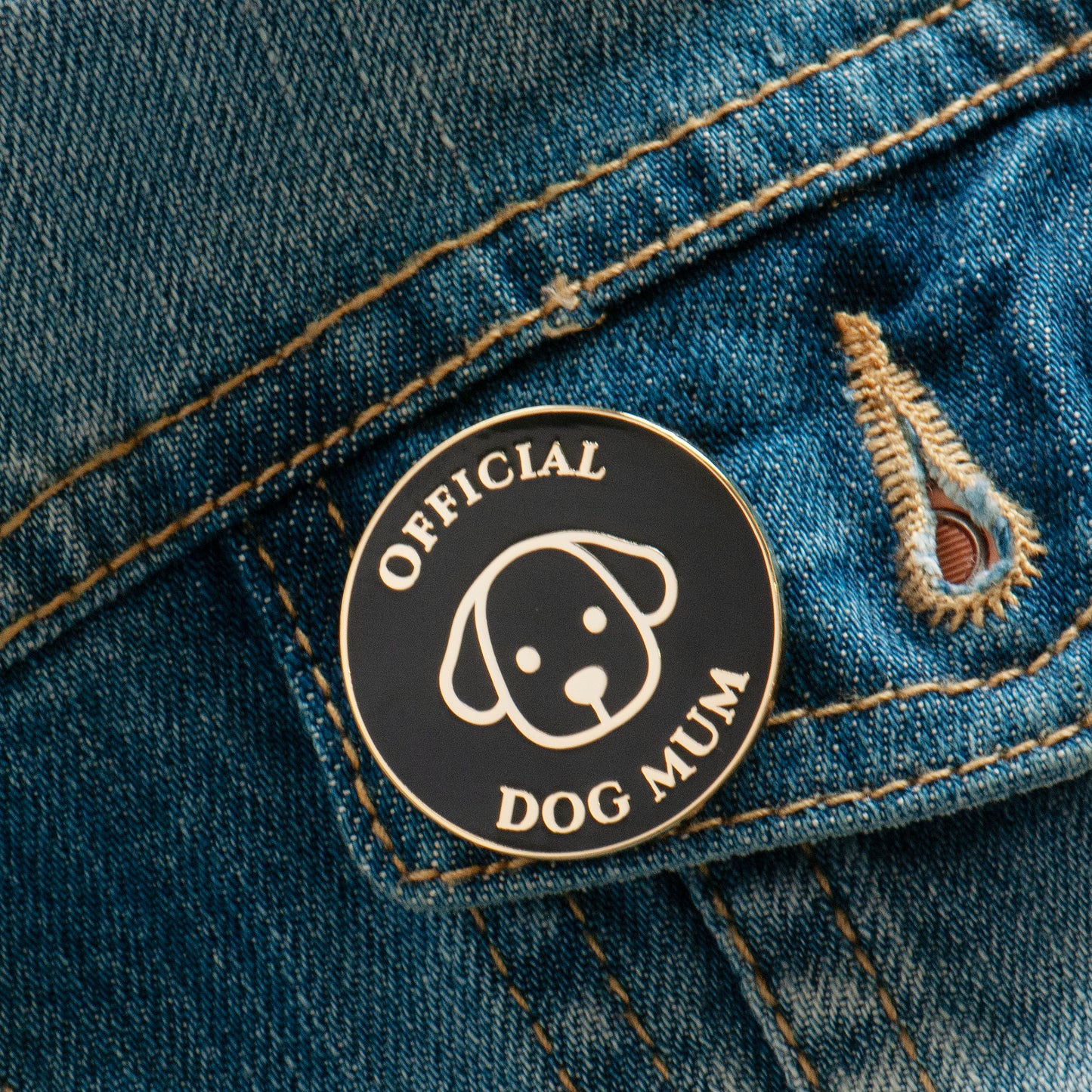 Black and gold official dog mum enamel pin on jacket pocket, super cute dog mum gift.