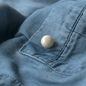 Ceramic modesty pin on shirt pocket for added detailing
