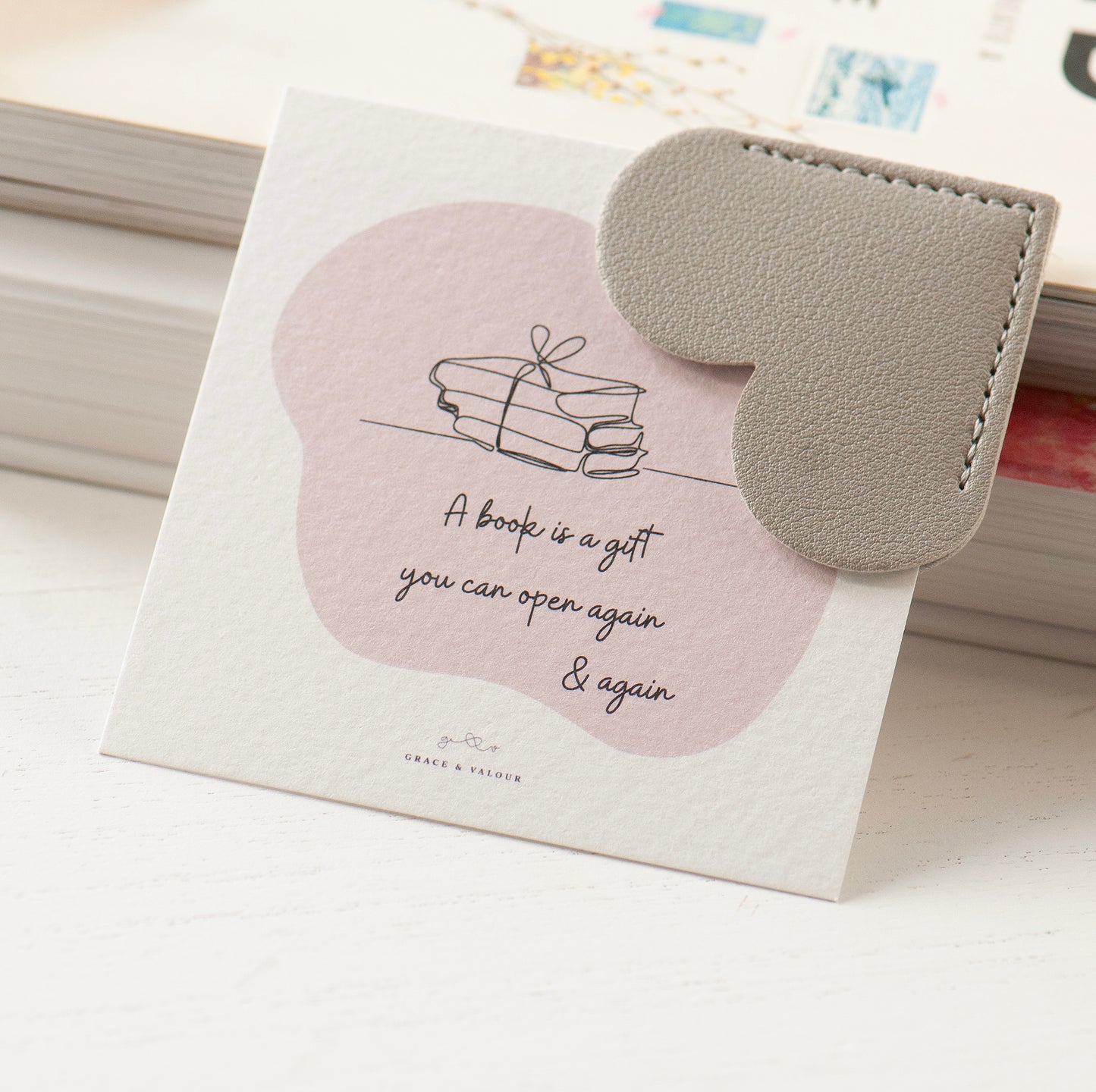 Grey heart shaped bookmark on bespoke gift card which reads 'A book is a gift you can open again and again'