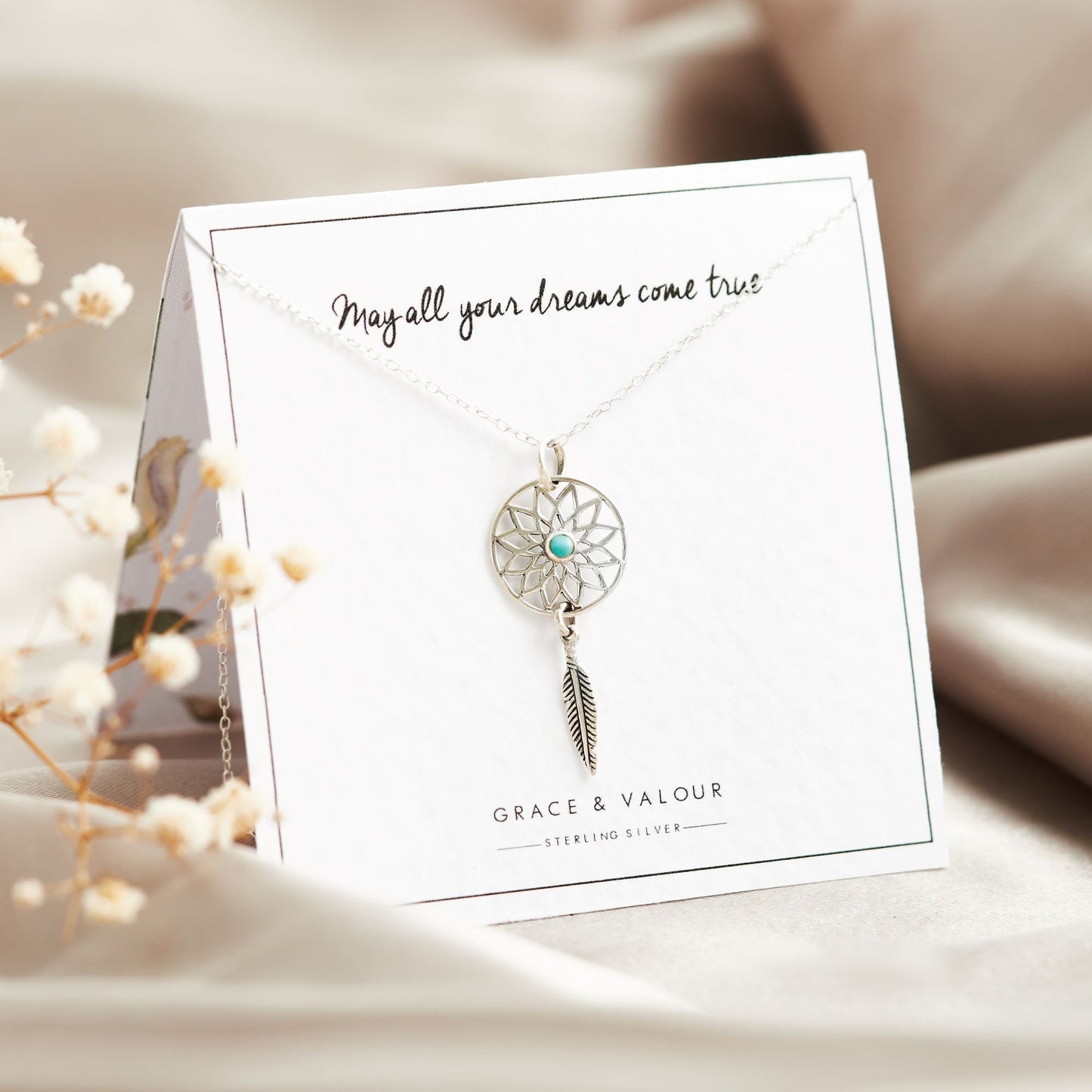Dream catcher sterling silver necklace with turquoise stone at the centre and dangling silver feather motif, on bespoke gift card that says - May all your dreams come true