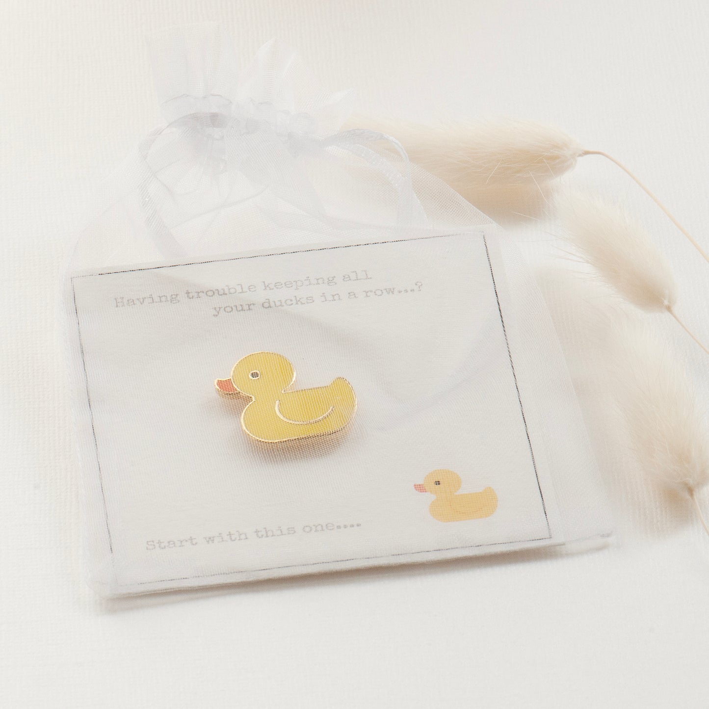 Ducks in a row giftcard and yellow cute rubber duck pin in a white chiffon pouch, readyu for gifting