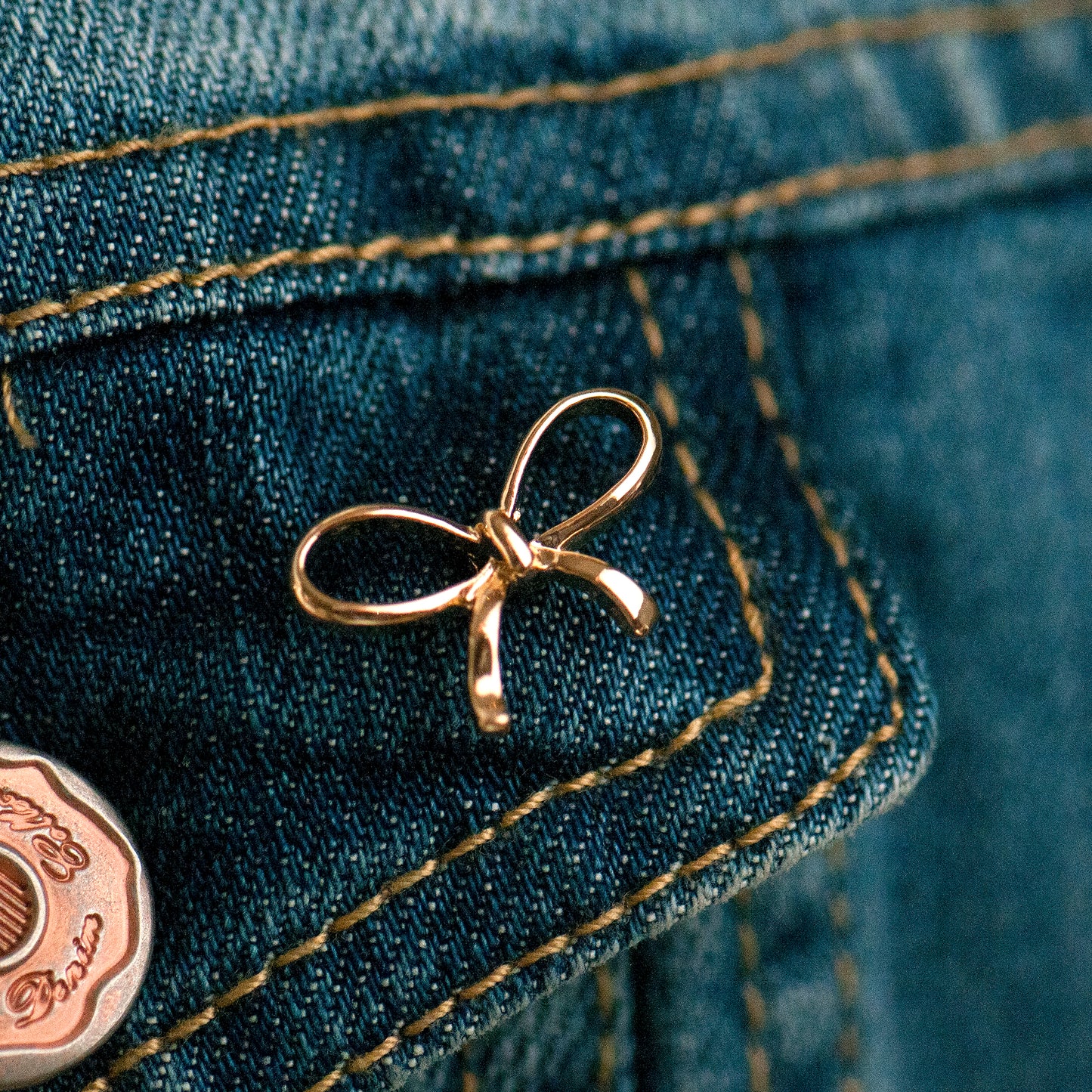 Gold bow modesty pin on pocket lapel as decoration