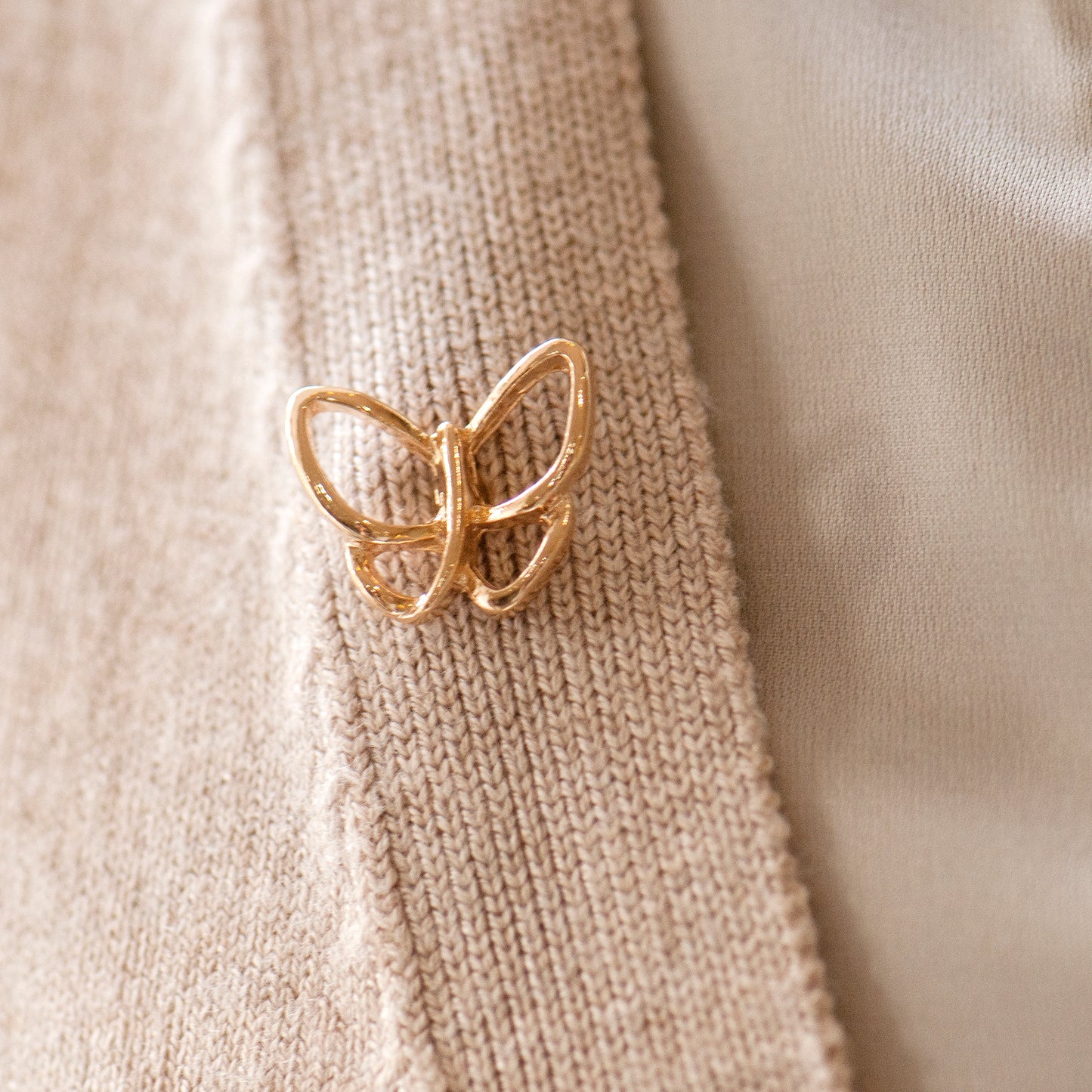 Gold butterfly pin worn as a lapel pin