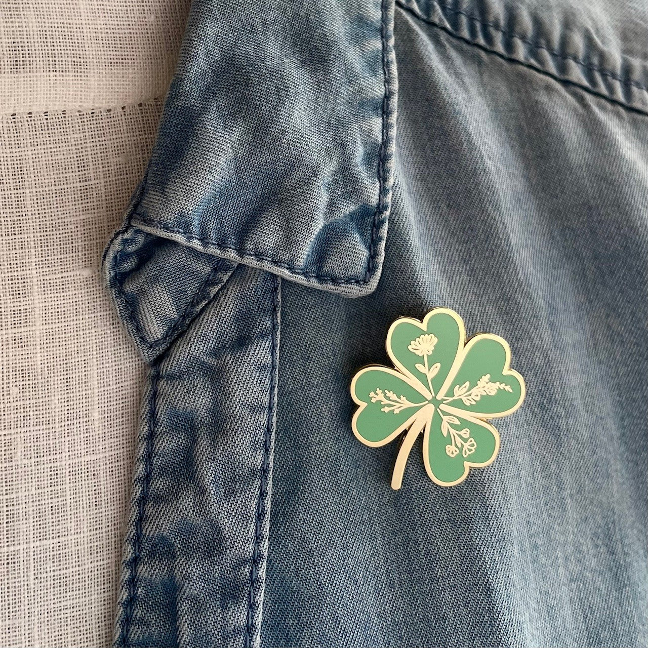 Good luck green and gold clover lapel pin worn casually on a shirt, gifts under £10, good luck gift, lucky gift, exam gift, driving test gift