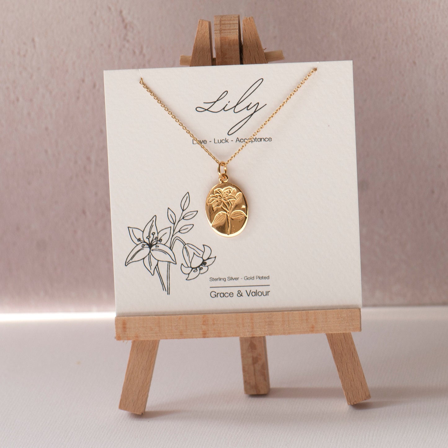 Gold plated engraved lily flower necklace, made from sterling silver and arrives on our bespoke Lily flower giftcard with information on the meanings of the lily flower - floriography. Designed by Rachel - Grace & Valour