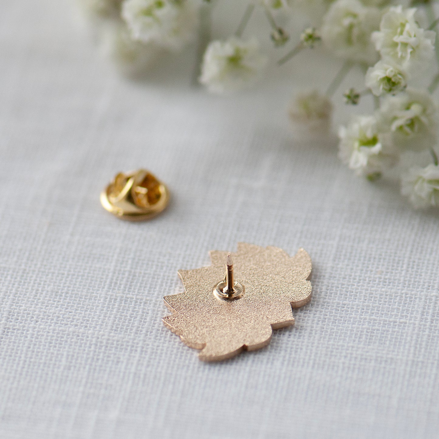Lotus flower enamel pin showing the back of the pin and the locking catch