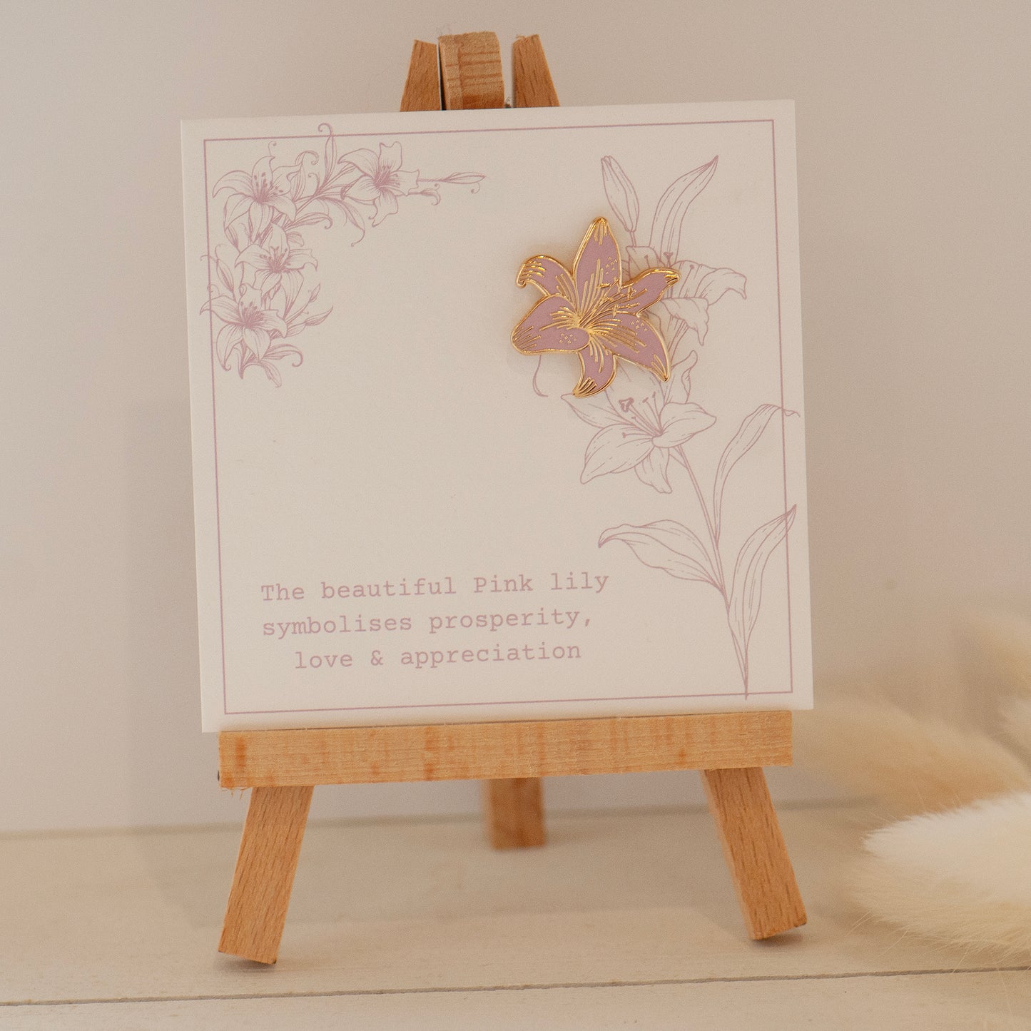 Pink and gold detailed stargazer lily enamel pin on my bespoke lily gift card which says 'The beautiful pink lily symbolises prosperity, love & appreciation'. Gifts under £10, flower gifts