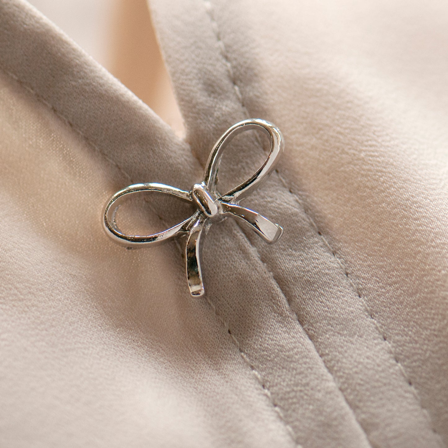 Silver bow modesty pin on low cut blouse