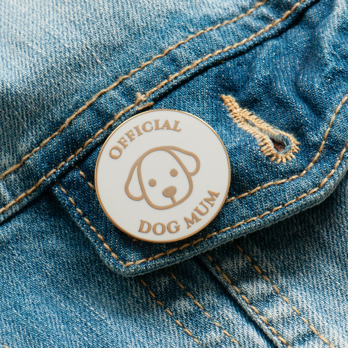 White and gold official dog mum enamel pin on jacket pocket, super cute dog mum gift.