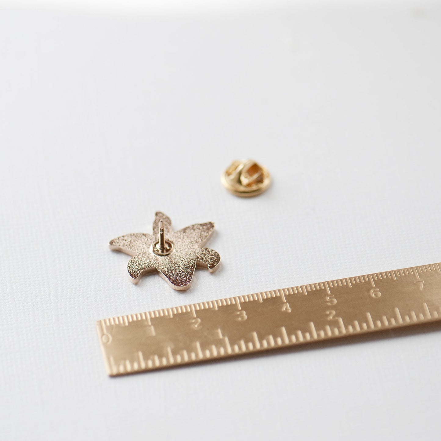 White stargazer lily enamel pin view of the back of the pin and locking clasp