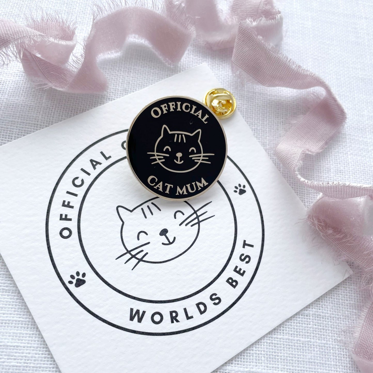 Pin with 'Official Cat Mum' text and cat illustration on a white card with pink ribbons.