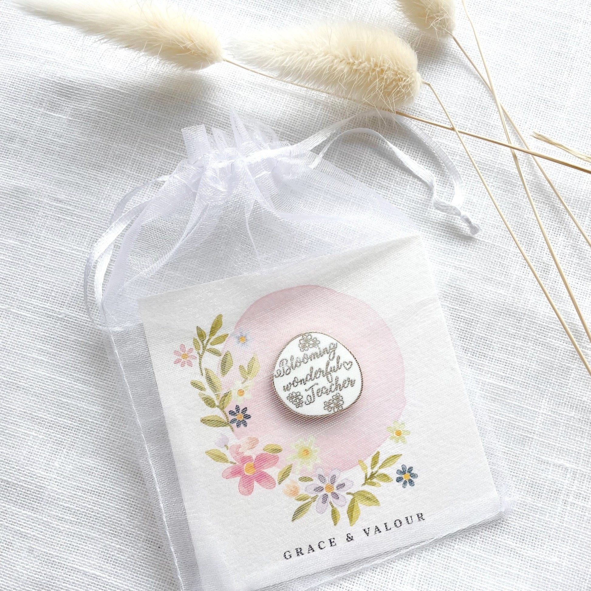 Floral card design and a 'Blooming wonderful teacher' pin.