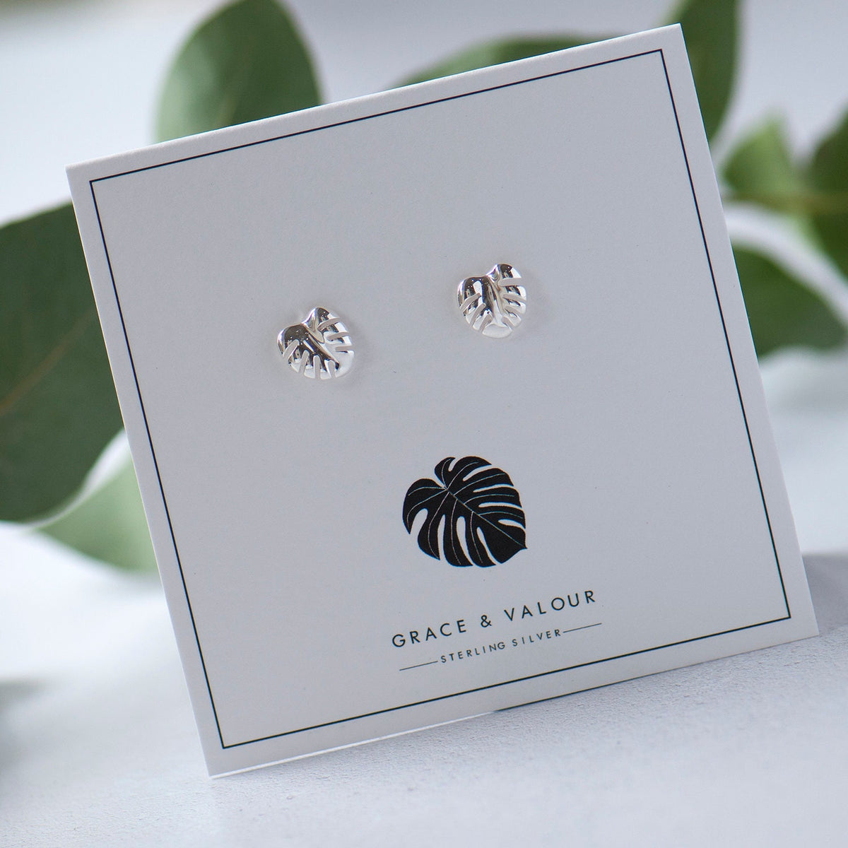 silver monstera leaf studs on a monstera leaf gift card