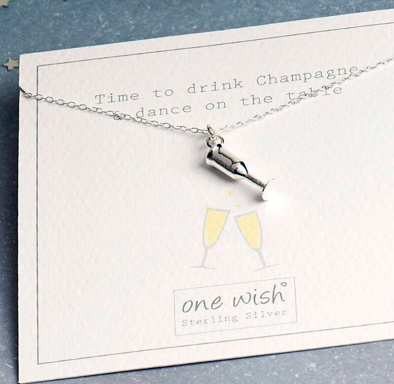 champagne flute pendant on a quote with a picture of two champagne glasses clinking and a quote about drinking champagne in celebration