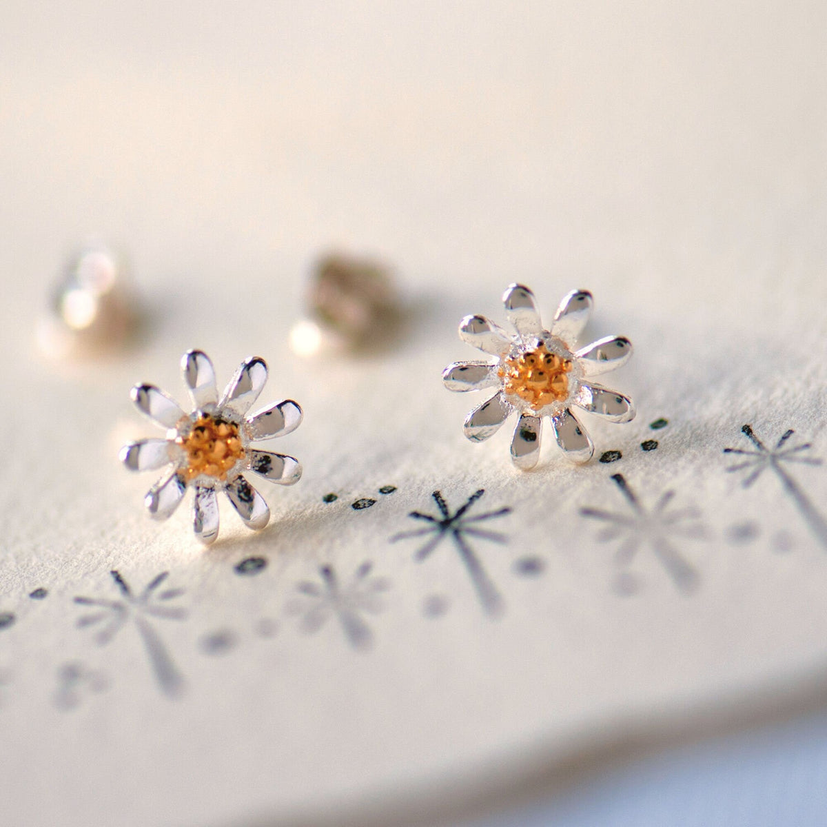 Sterling silver daisy stud earrings with gold flower centres