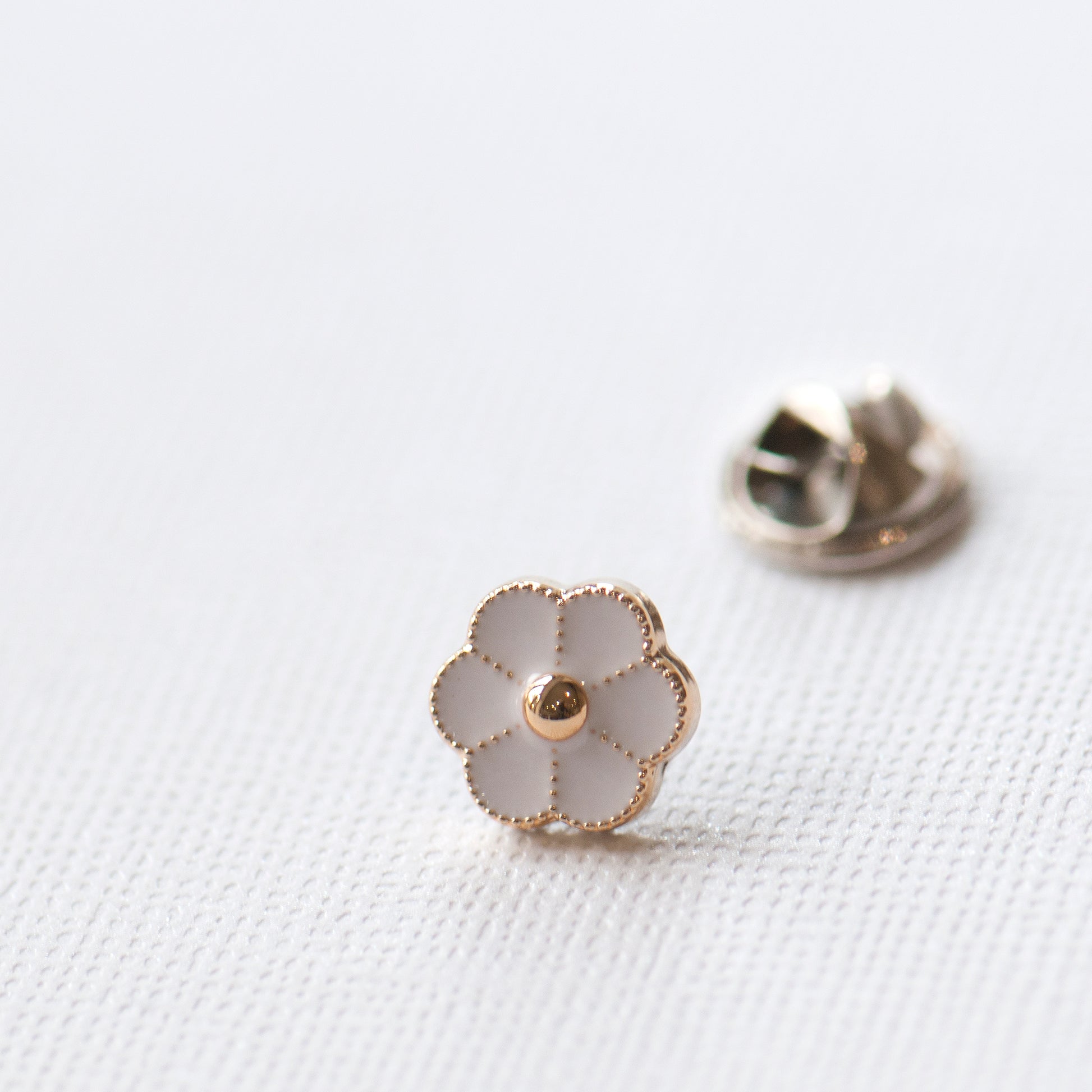 Tiny white enamel flower modesty pin close up picture