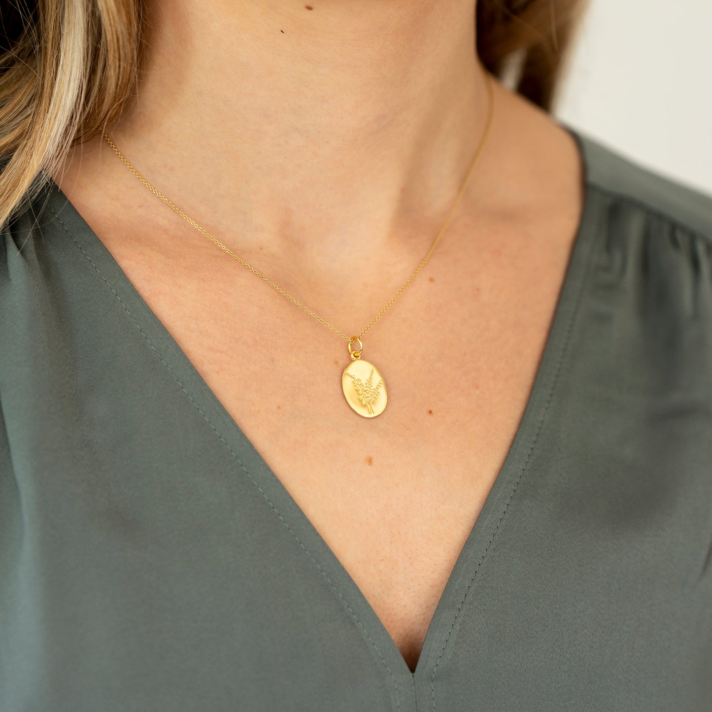 Model wearing lucky heather gold oval necklace
