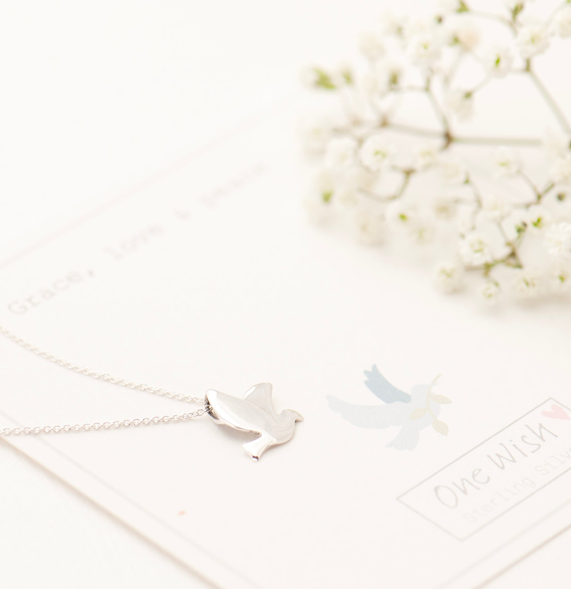 Silver dove necklace on a white giftcard ready for gifting