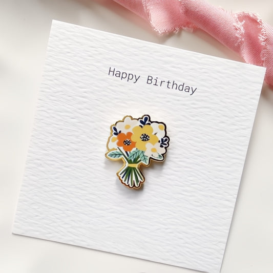 Bunch of cheerful orange and yellow flowers enamel pin on a 'Happy Birthday' card.