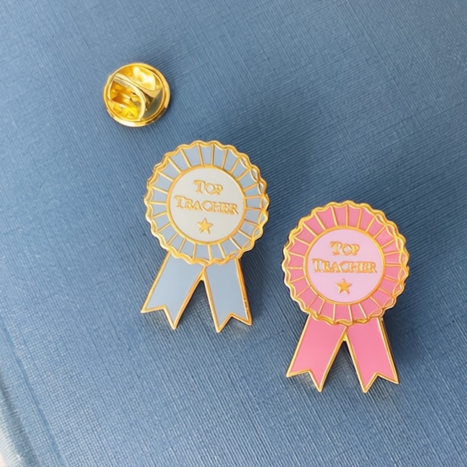 Two 'Top Teacher' ribbons on a blue background