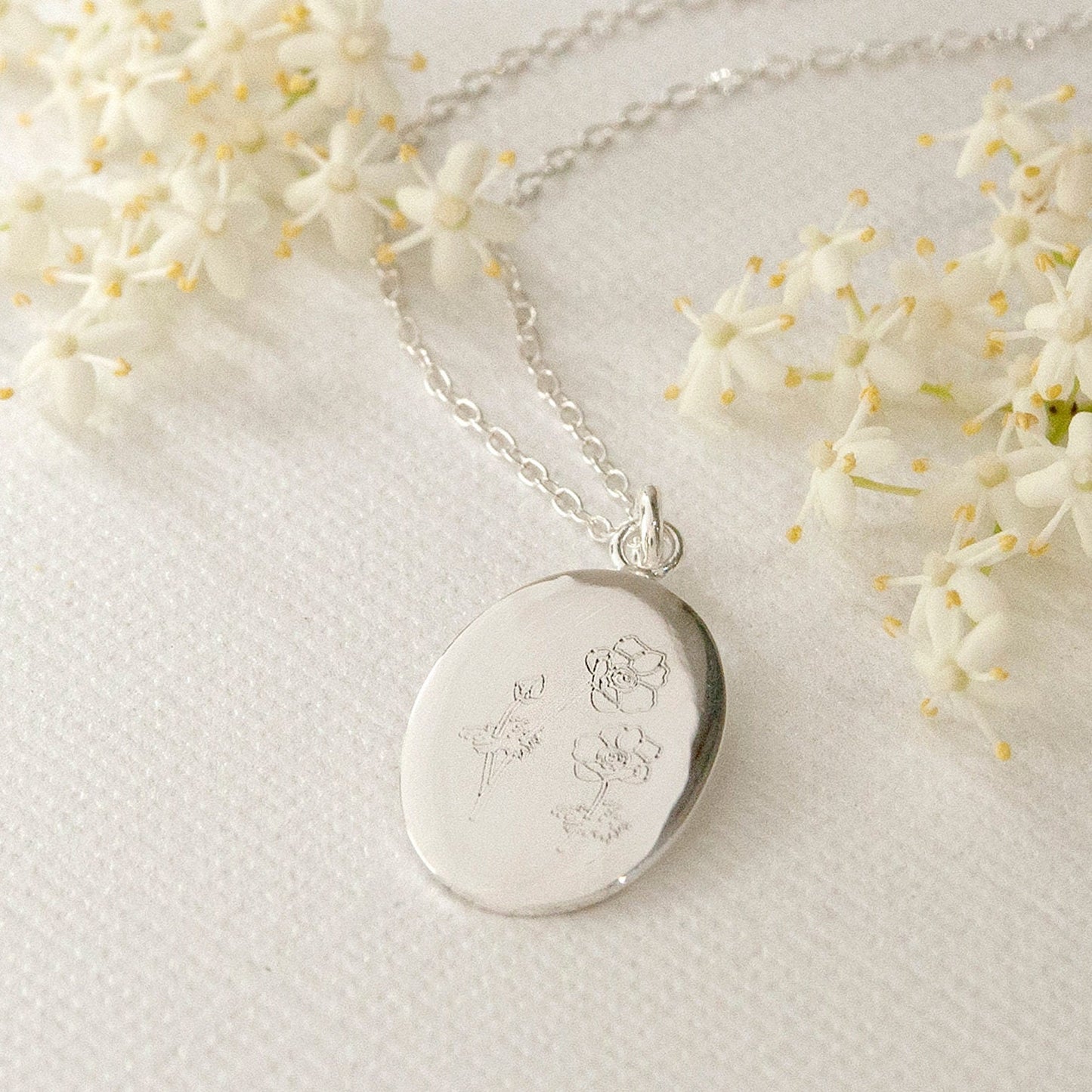 oval sterling silver pendant engraved with english wildflowers design