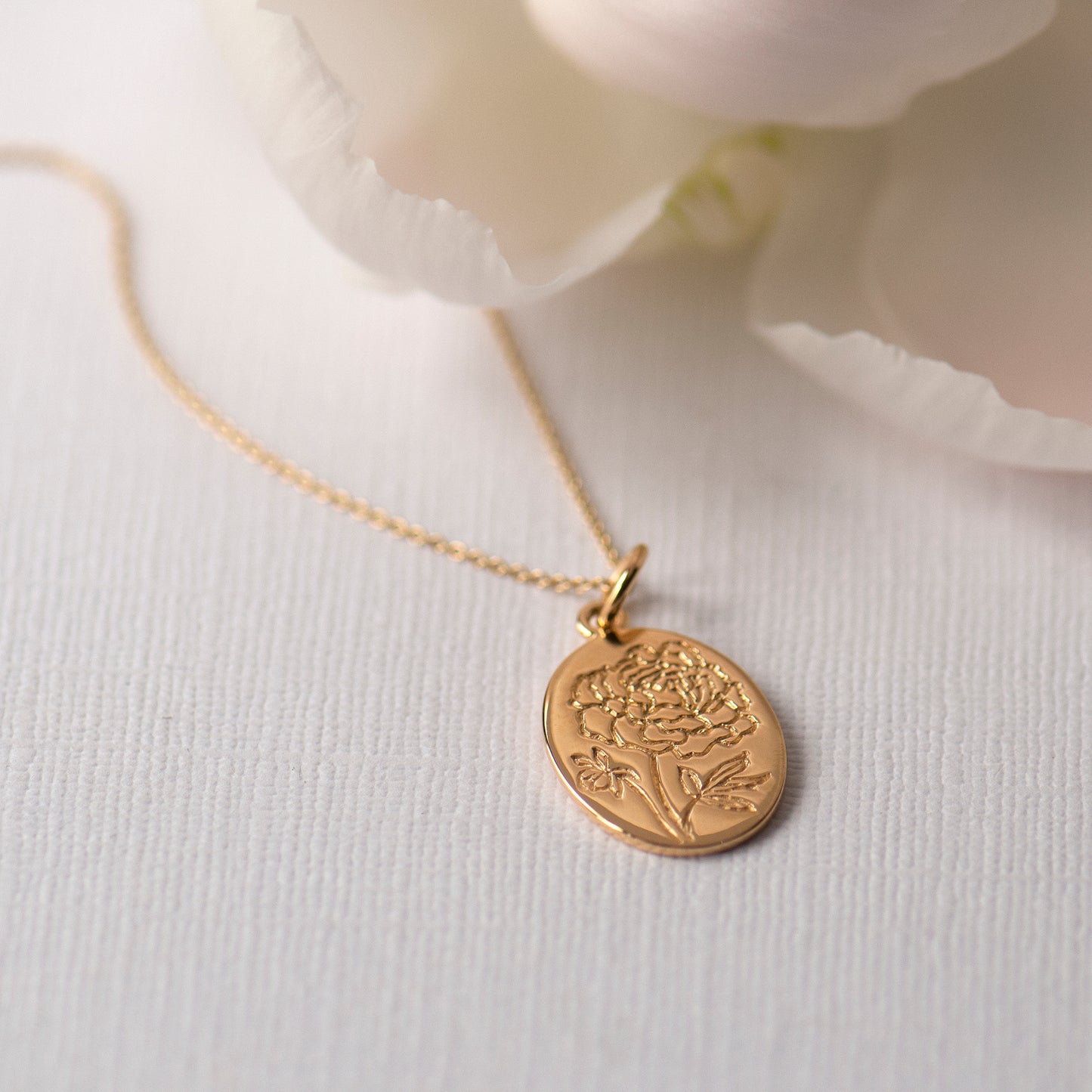peony necklace engraved on a gold oval pendant on a dainty matching chain.