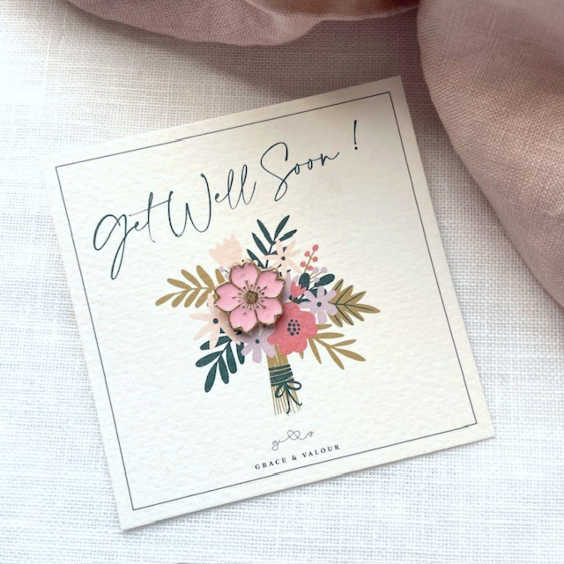 Get well soon card with floral design with a pink flower pin badge gift
