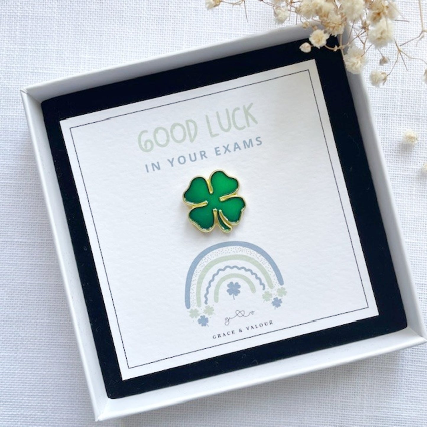 Four-leaf clover pin in a gift box with 'Good Luck in Your Exams' card