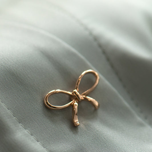 Gold bow modesty pin on low cut blouse