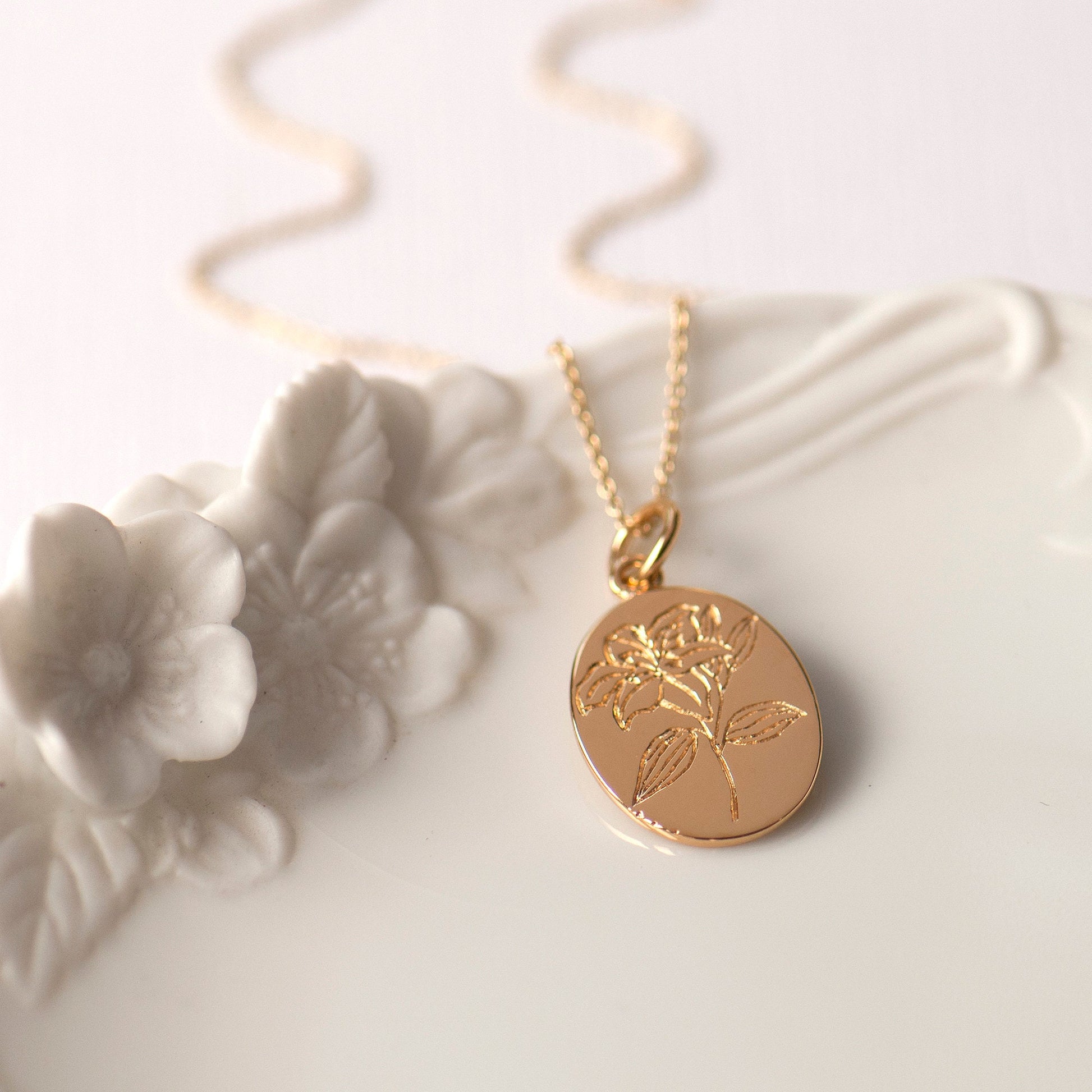 Gold plated engraved lily flower necklace, made from sterling silver and arrives on our bespoke Lily flower giftcard with information on the meanings of the lily flower - floriography.  Designed by Rachel - Grace & Valour