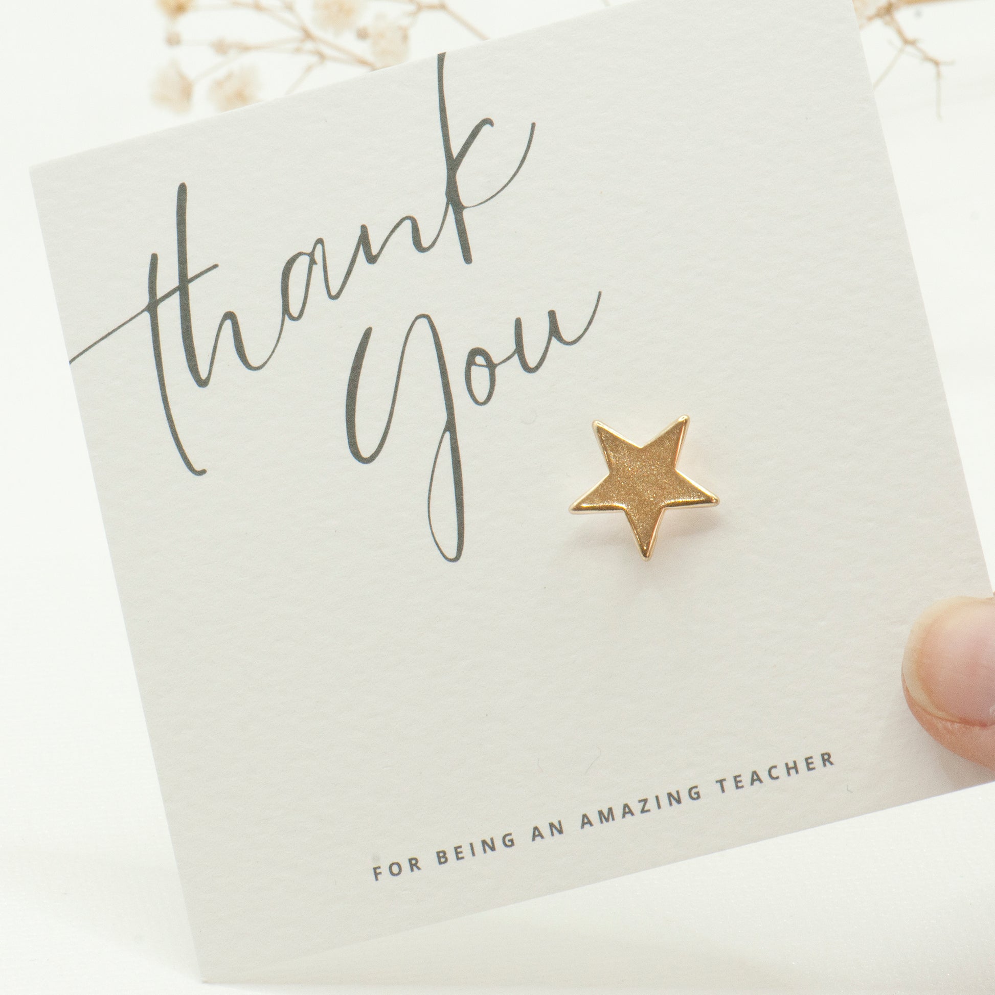 Gold star lapel pin on a 'Thank You for being an amazing teacher' card