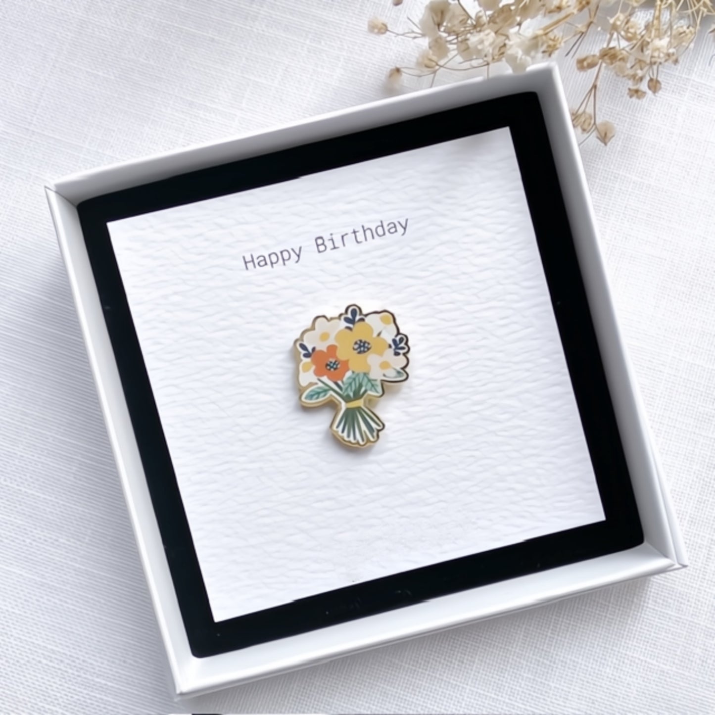 Floral pin in a 'Happy Birthday' card with a white box on a light background