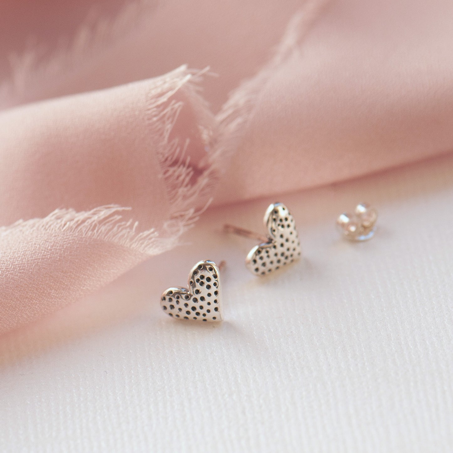 Close up of sterling silver heart textured stud earrings