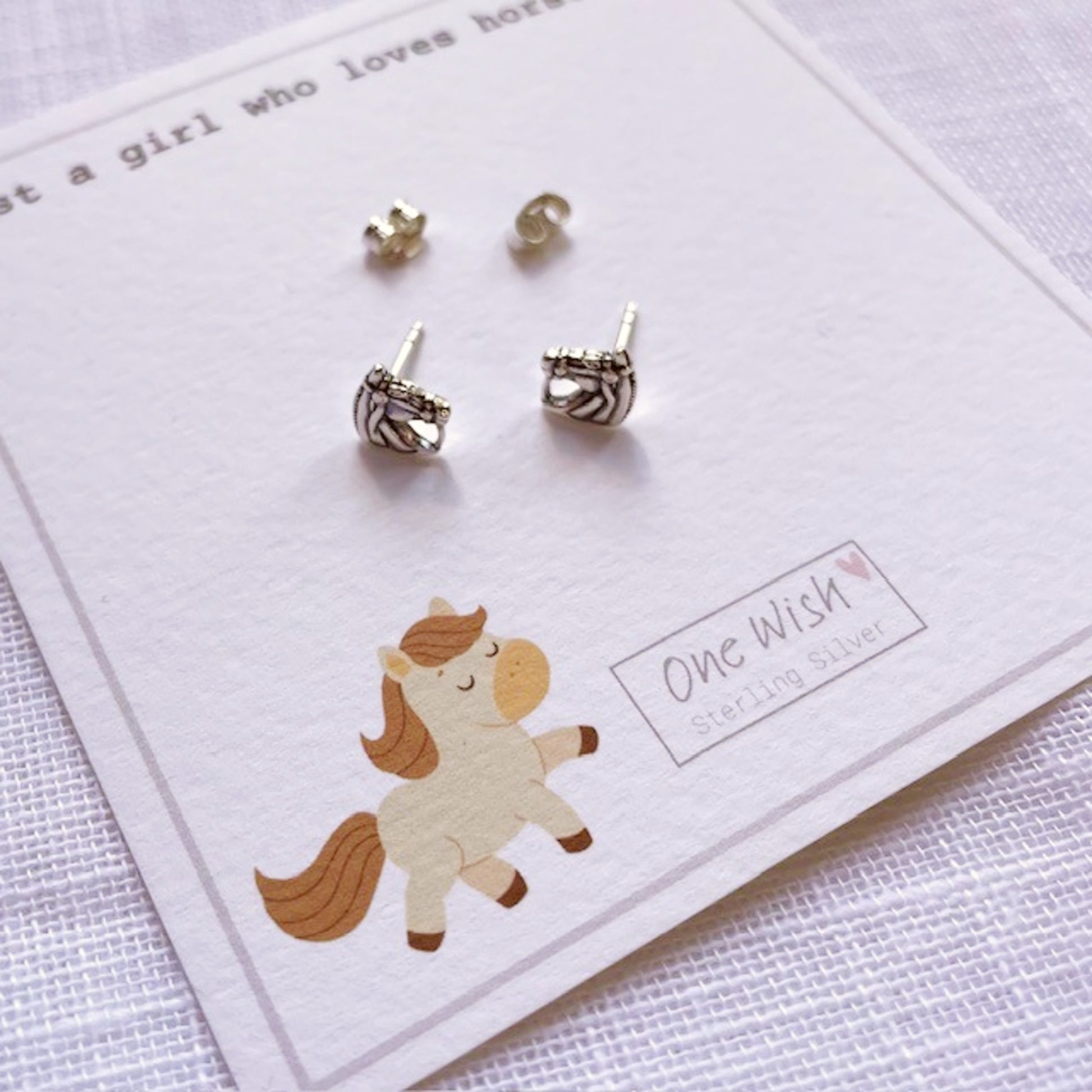 Set of silver earrings on a card with a horse illustration and 'One Wish' branding.