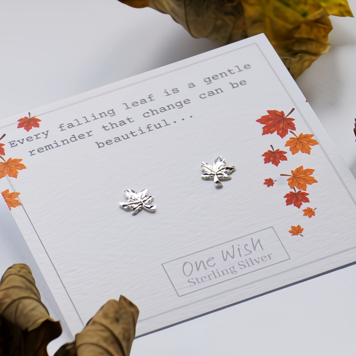 Sterling silver leaf stud earrings displayed on a white gift card with autumn leaf illustrations and the text 'One Wish Sterling Silver'.