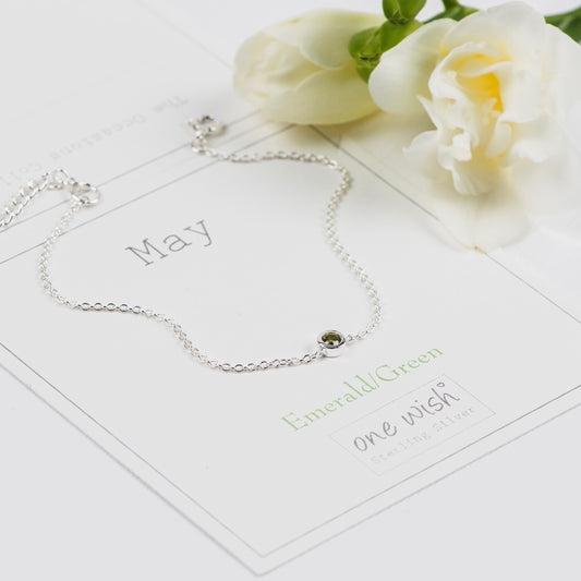 Silver bracelet with an emerald green gemstone on a May birthday gift card