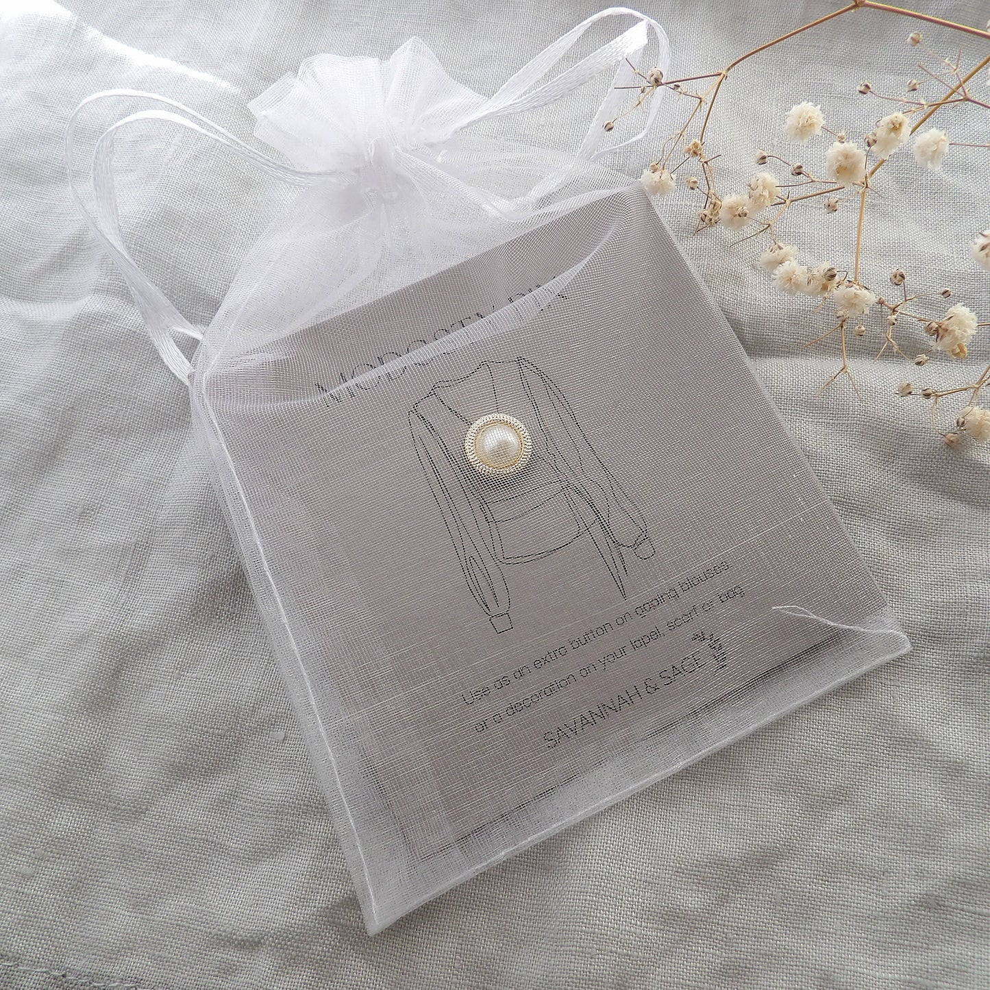 white pearl modesty pin in chiffon pouch packaging