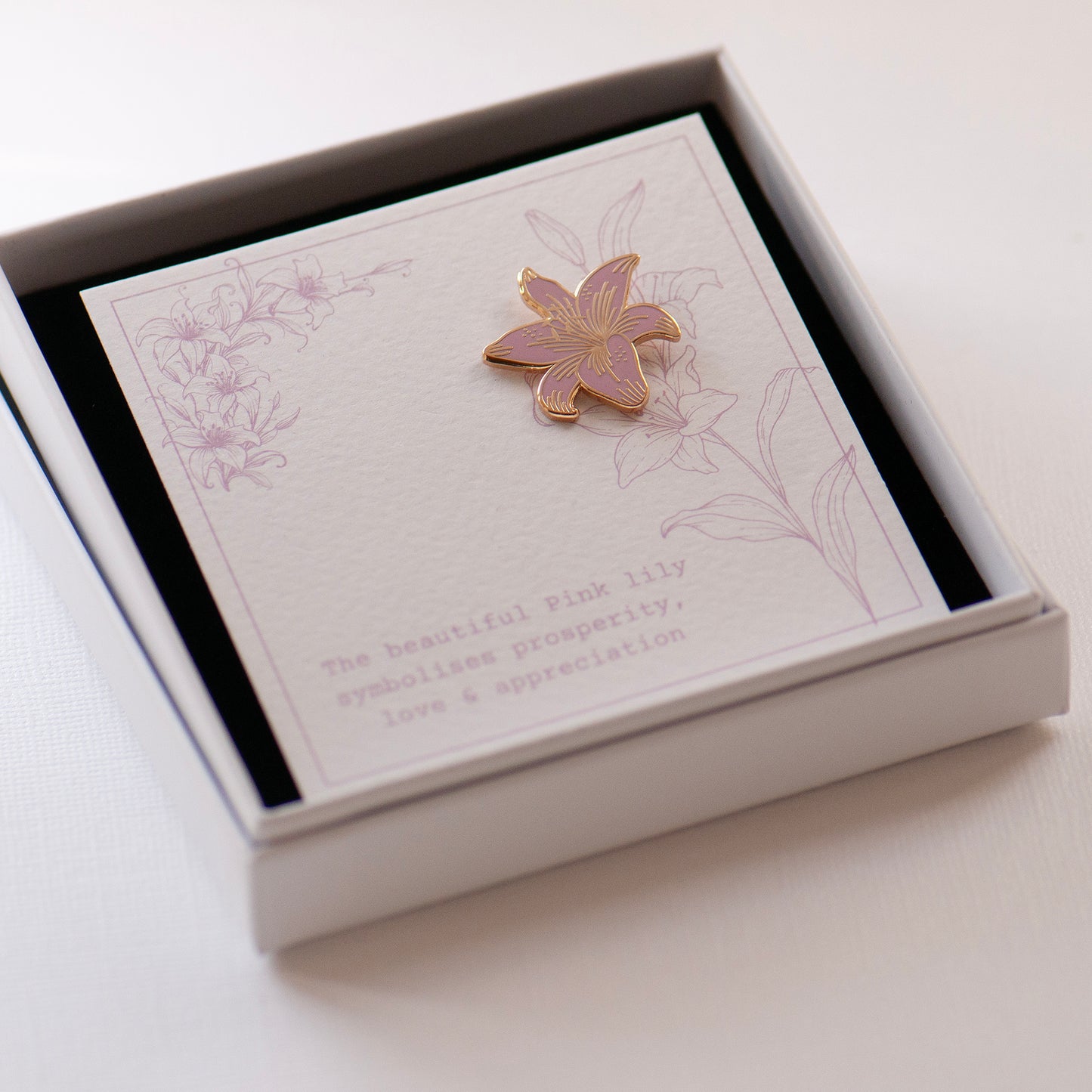 Pink and gold detailed stargazer lily enamel pin on my bespoke lily gift card which says 'The beautiful pink lily symbolises prosperity, love & appreciation'. Presented in an an elegant white gift box.  gifts under £10, flower gifts