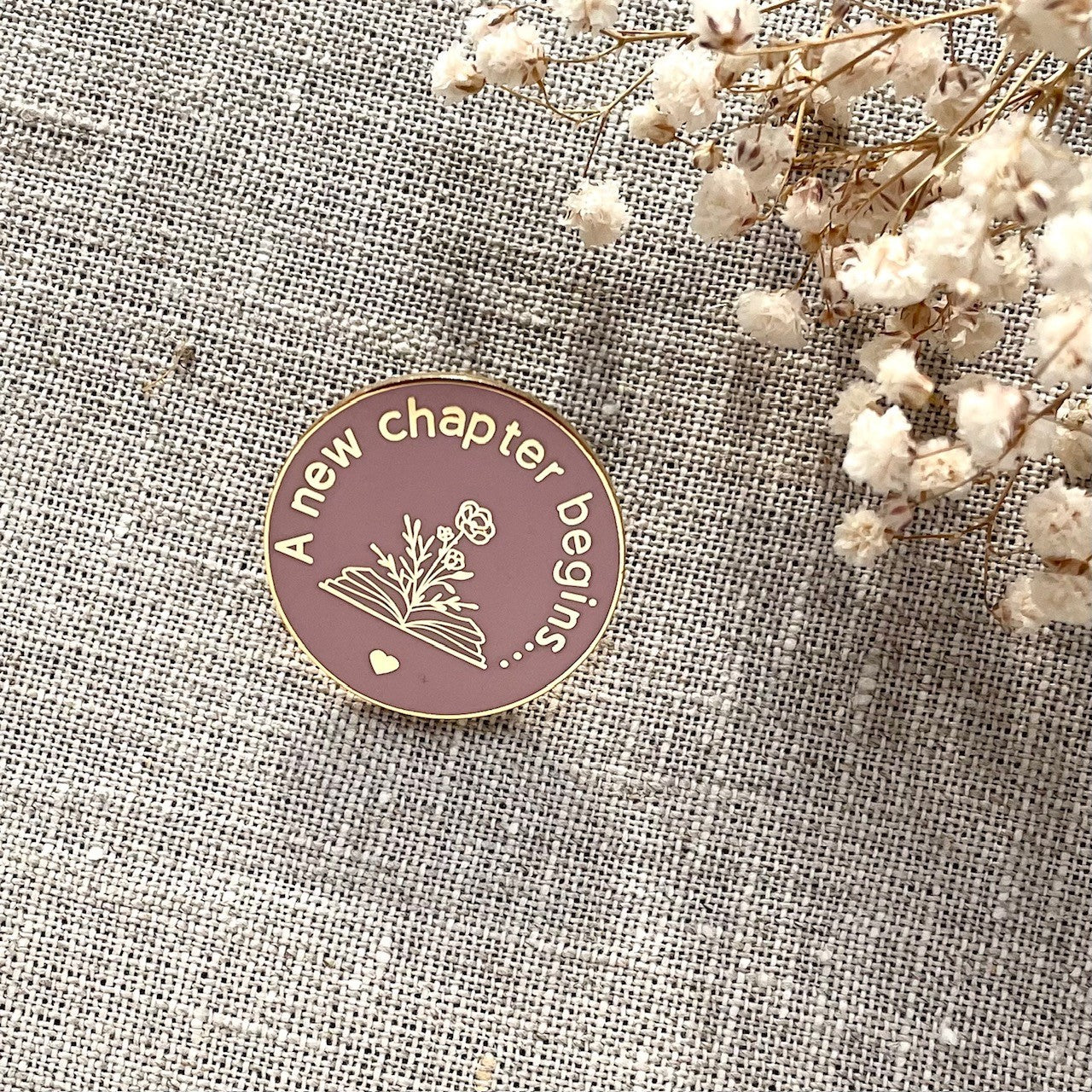 Pretty gold and smoke rose new chapter begins round pin. Gifts under £10, new home gift, new job gift, new baby gift, travelling gift, retirement gift