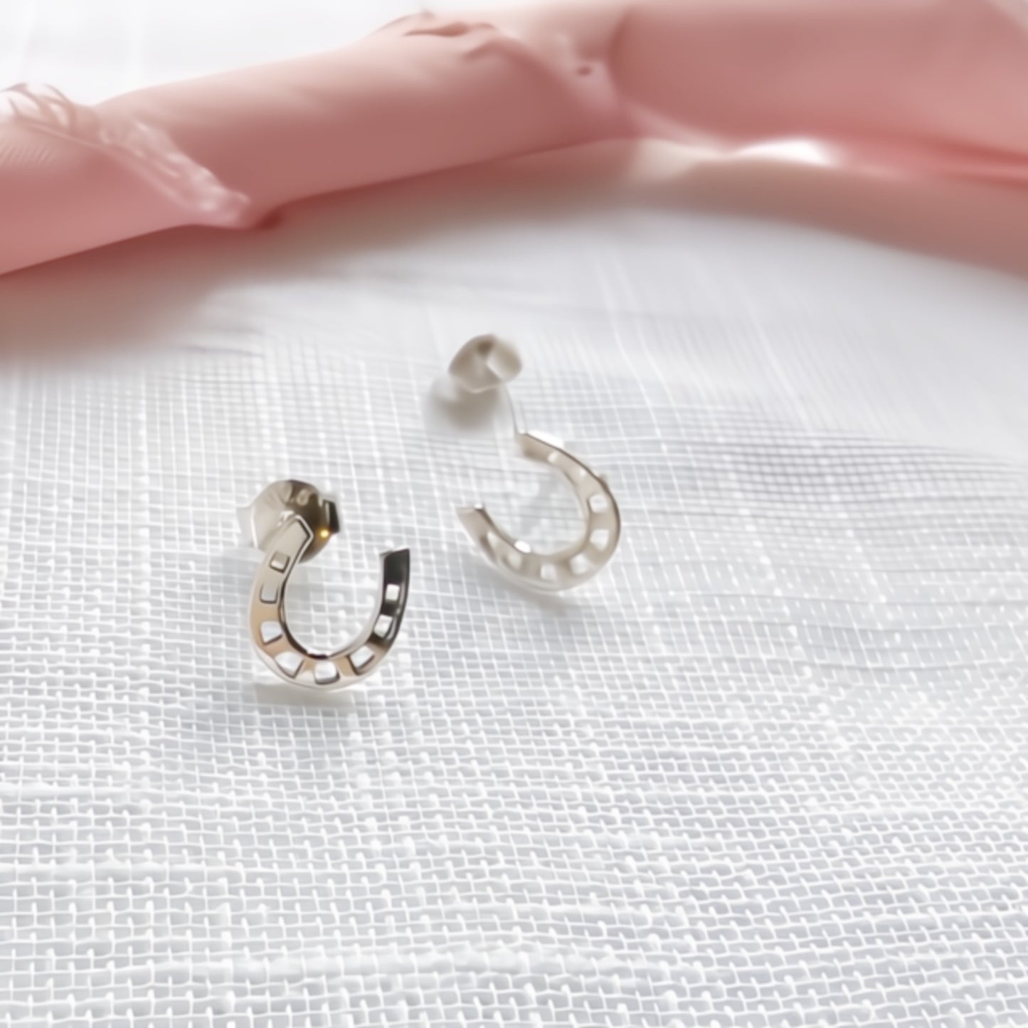 Silver horseshoe-shaped earrings close up details shot