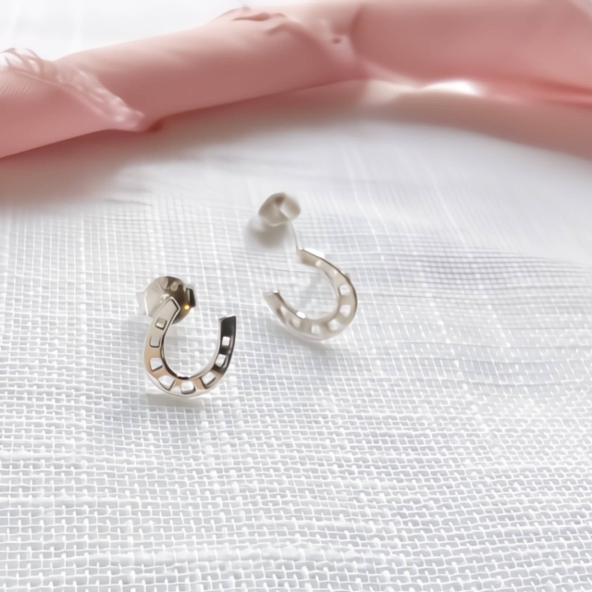 Silver horseshoe-shaped earrings close up details shot