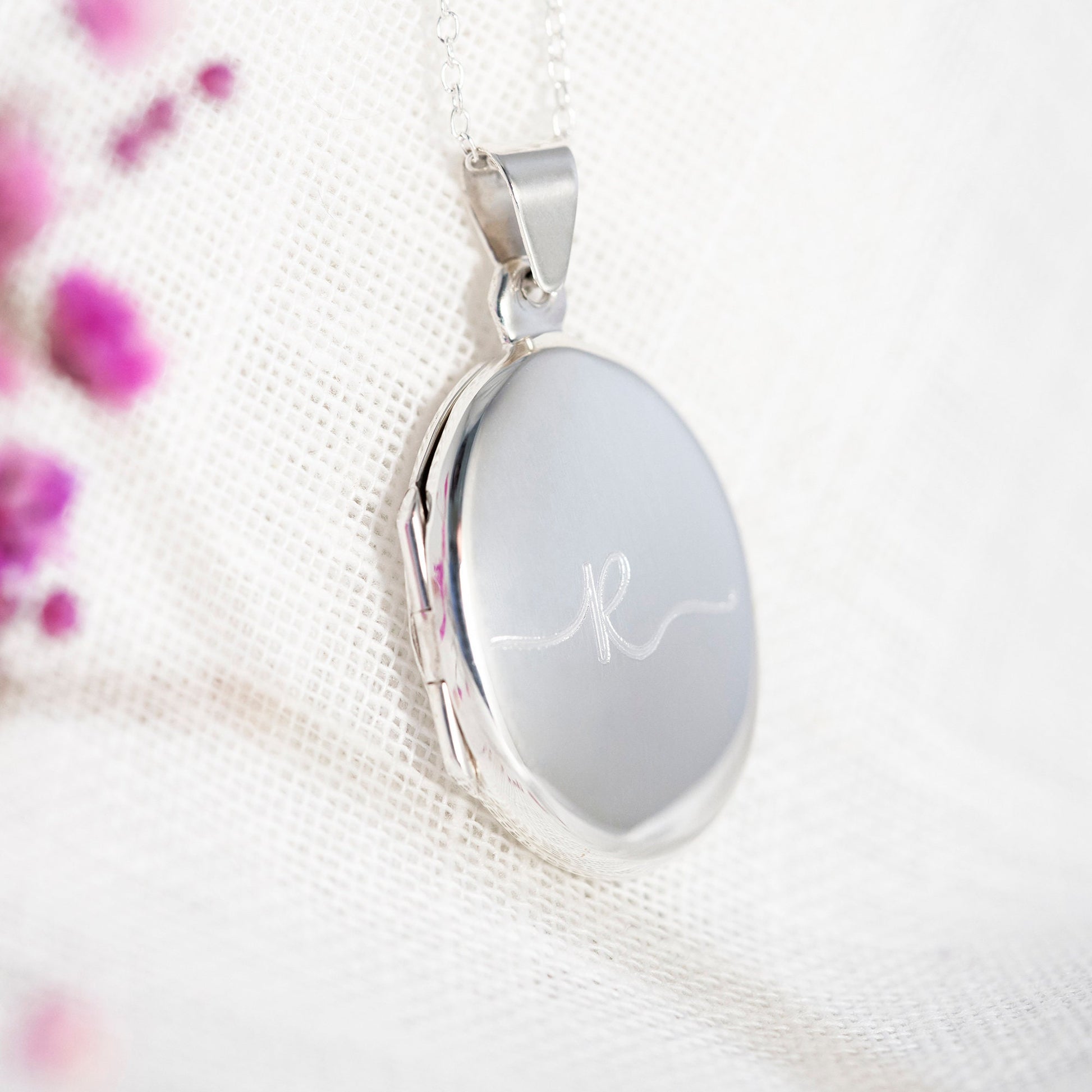 Sterling silver oval polished locket engraved with an initial R in a flowing font. This is a contemporary design locket, its highly polished and the engraving stands out beautifully. The locket holds two photographs and can be engraved on the reverse with your personal gift message. A great silver 925 gift for her, gift for wedding, gift for bridesmaids, thoughtful birthday gift, remembrance locket with photos