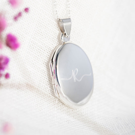 Sterling silver oval polished locket engraved with an initial R in a flowing font. This is a contemporary design locket, its highly polished and the engraving stands out beautifully. The locket holds two photographs and can be engraved on the reverse with your personal gift message. A great silver 925 gift for her, gift for wedding, gift for bridesmaids, thoughtful birthday gift, remembrance locket with photos