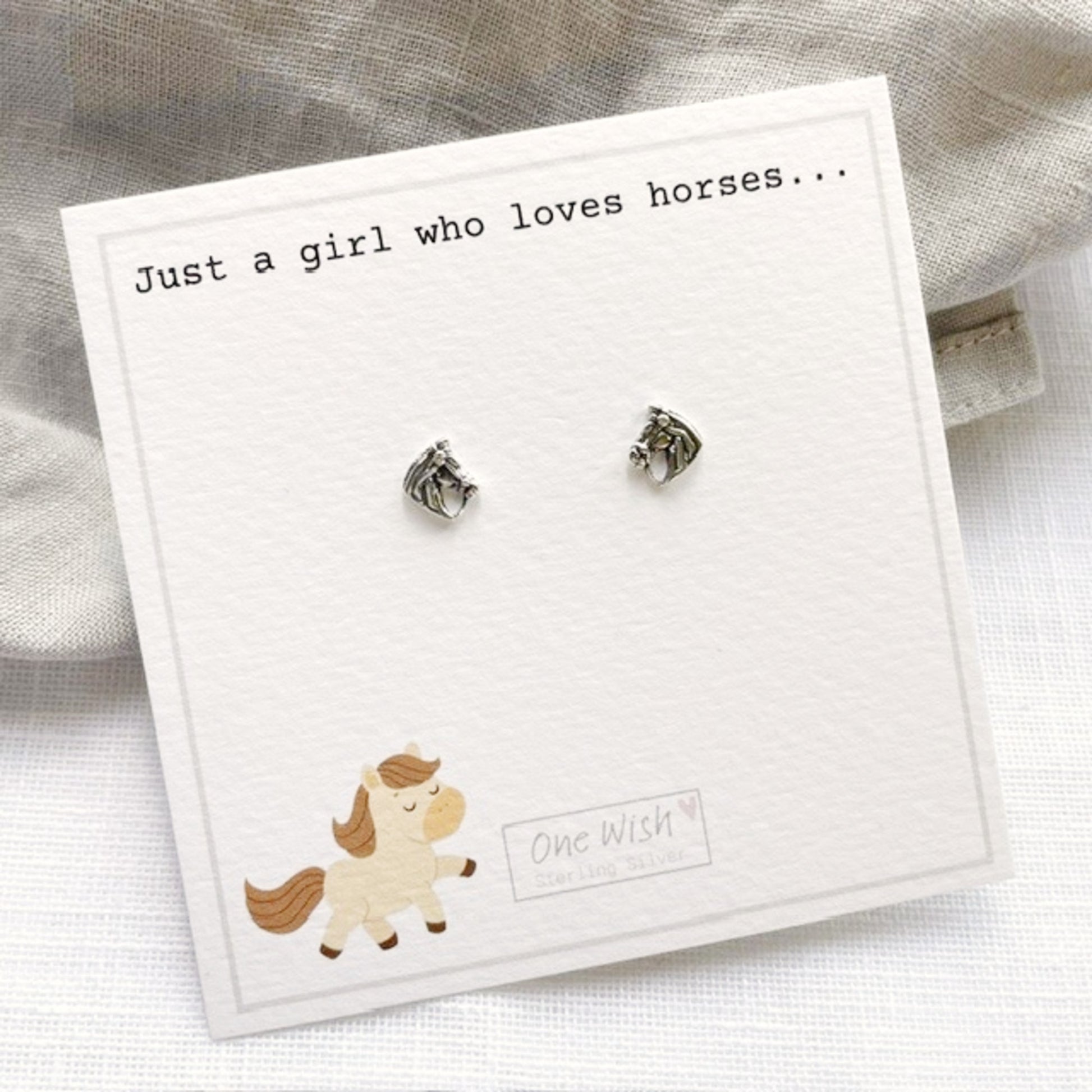 Horse-shaped earrings on a card with text and branding