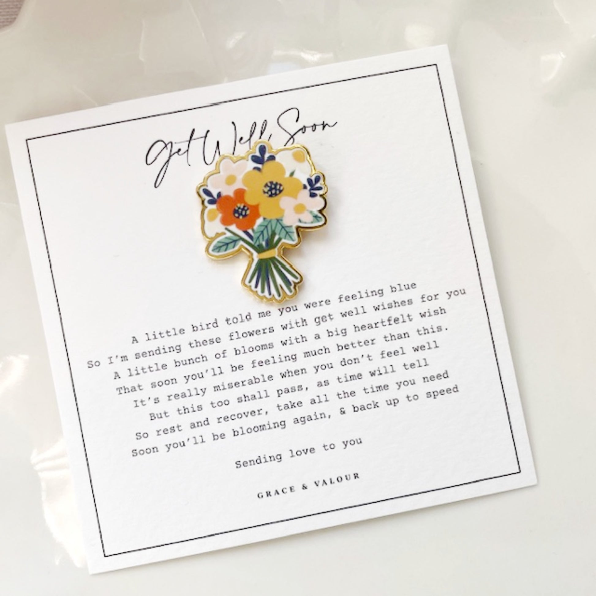 Floral brooch on a 'Get Well Soon' card with text