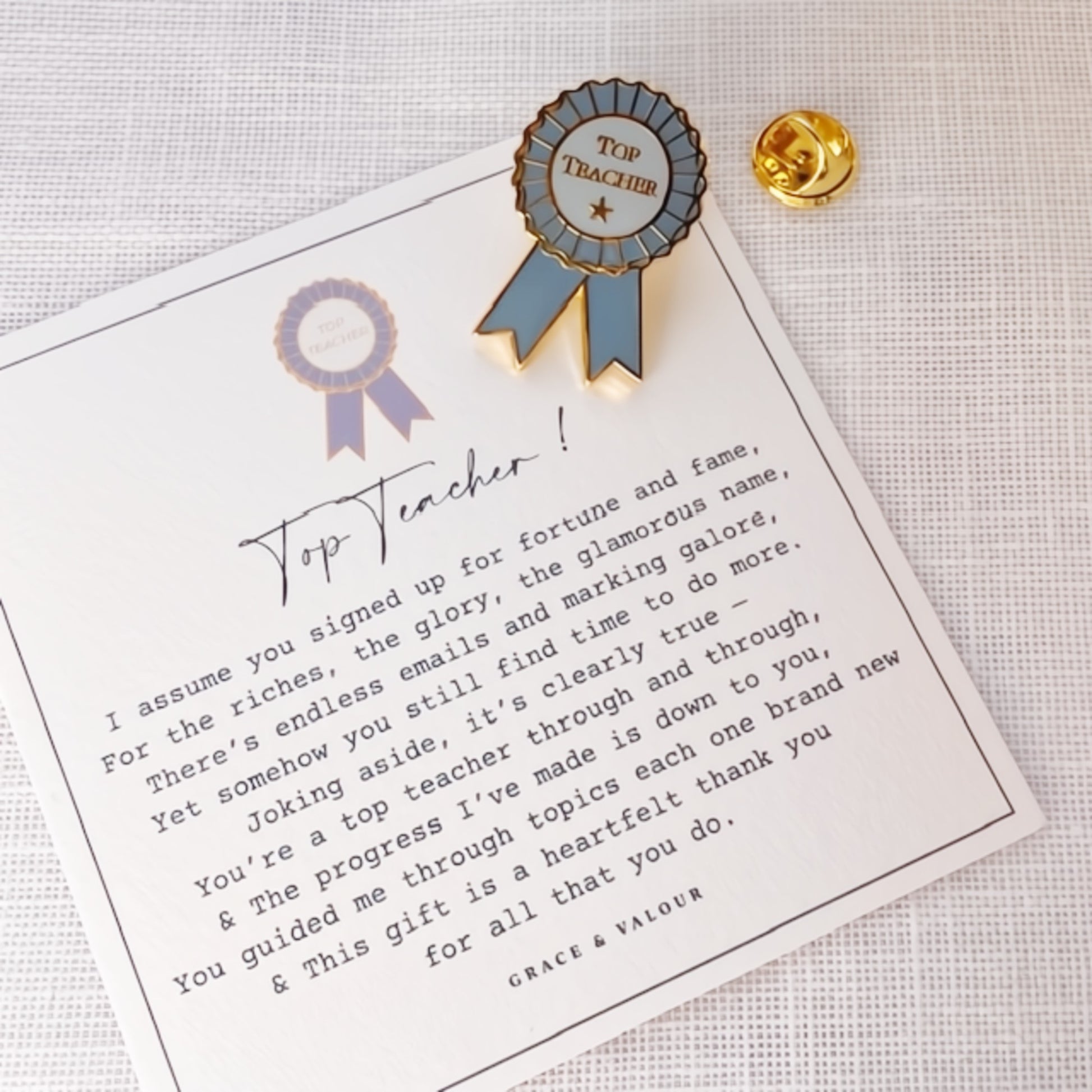 Pin with 'Top Teacher' ribbon on a card with text