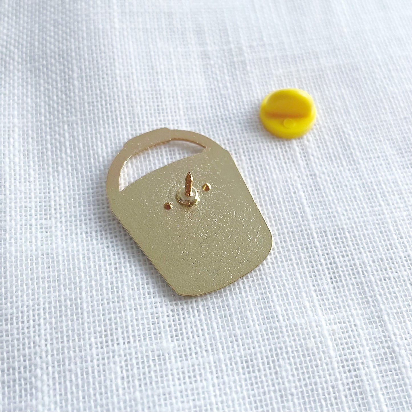 Back of the gold F*ck it bucket on a white fabric background