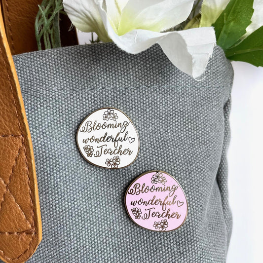 Two pins with 'Blooming wonderful Teacher' text on a gray marking bag