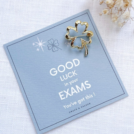 Gold four-leaf clover brooch on a card with 'Good Luck in your Exams' message