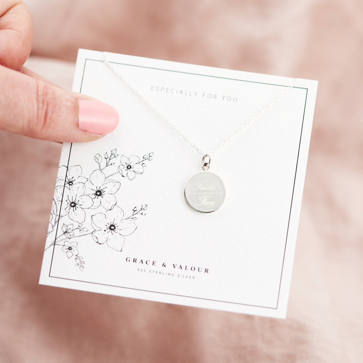 silver engraved necklace on a floral gift card